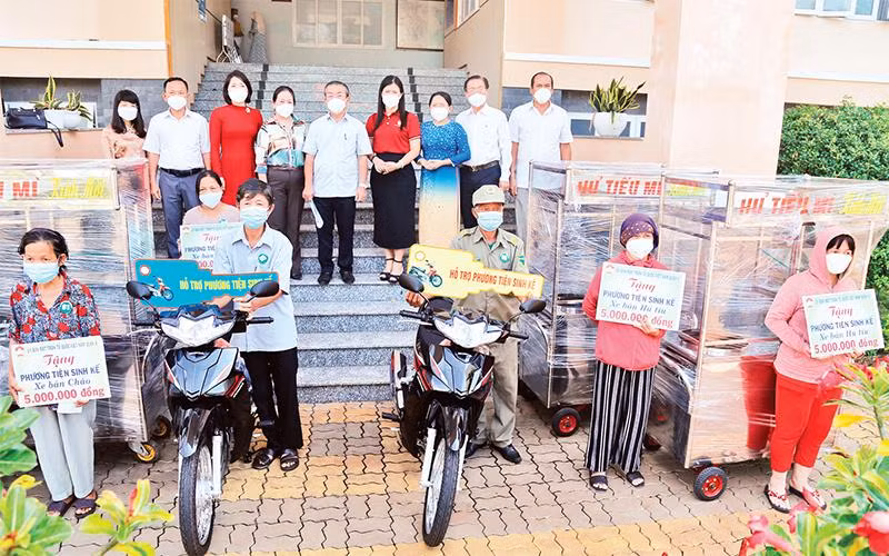 Các đơn vị phối hợp trao phương tiện sinh kế cho người dân nghèo trên địa bàn quận 8. 