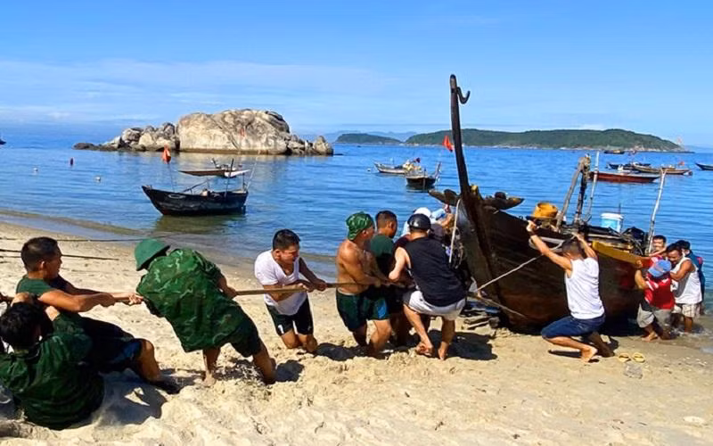Lực lượng cứu hộ kéo tàu cá QNa-02211 lên bờ.