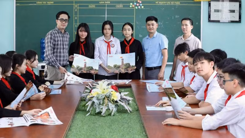 Đại diện Văn phòng Báo Nhân Dân tại Lạng Sơn trao ấn phẩm đặc biệt" Cột cờ Hà Nội" cho giáo viên và học sinh trường Trung học sơ sở thị trấn Bắc Sơn, huyện Bắc Sơn (Lạng Sơn).