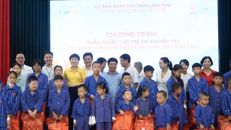 Các đại biểu và nhà hảo tâm tặng quà cho trẻ em khuyết tật được chỉ định phẫu thuật.