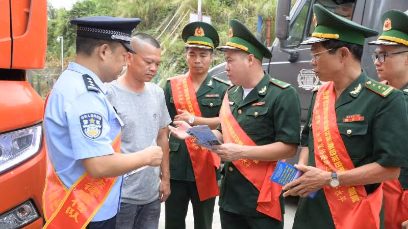 Cán bộ, chiến sĩ Bộ đội Biên phòng Lạng Sơn phối hợp với Trạm kiểm soát biên phòng Quảng Tây (Trung Quốc) tuyên truyền pháp luật cho lái xe chở hàng hóa qua cửa khẩu.