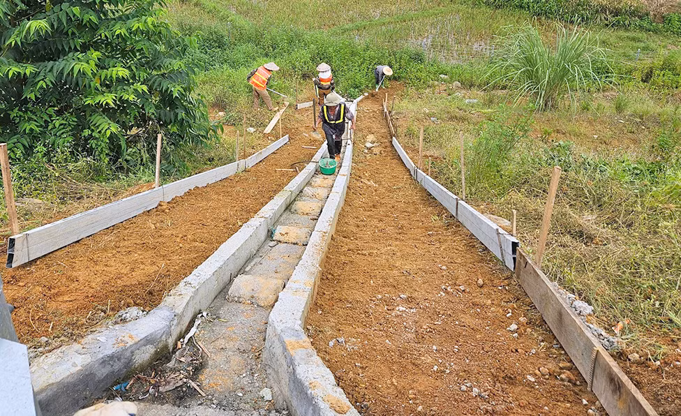 Công nhân thi công bổ sung rãnh thu nước mặt đường bê-tông xi-măng.