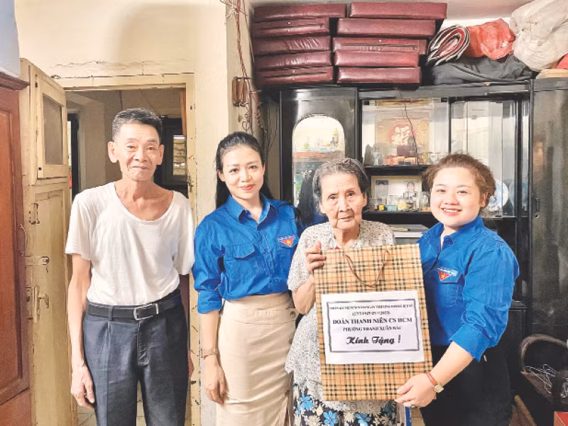 Bí thư Đoàn phường Thanh Xuân Bắc Lê Trà My (ngoài cùng bên phải) và các đoàn viên đến tặng quà gia đình chính sách trên địa bàn phường.