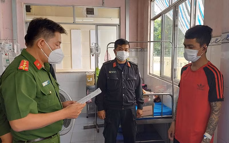 Công an tỉnh Đồng Tháp đọc lệnh bắt tạm giam đối tượng Phạm Hồng Qui. (Ảnh: Phước Thanh) 