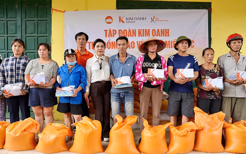 Bà Đặng Thị Kim Oanh (áo trắng) trao tặng gạo và tiền mặt hỗ trợ bà con ở xã Đào Thịnh, huyện Trấn Yên, tỉnh Yên Bái.
