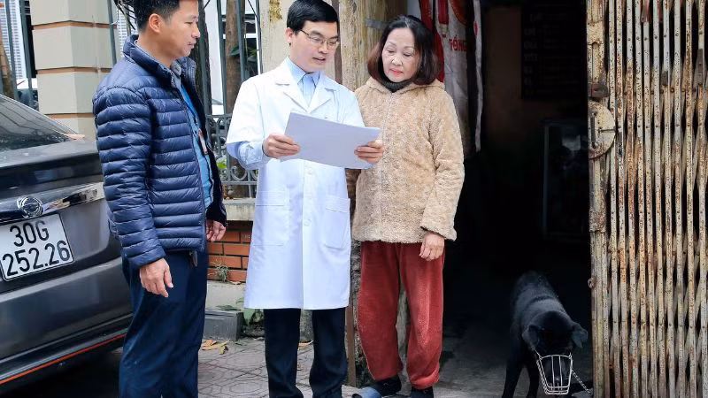 Cán bộ Trạm Y tế phường Thanh Nhàn, quận Hai Bà Trưng, Hà Nội tuyên truyền, hướng dẫn người dân phòng ngừa bệnh dại trên chó, mèo. (Ảnh HUY HOÀNG)