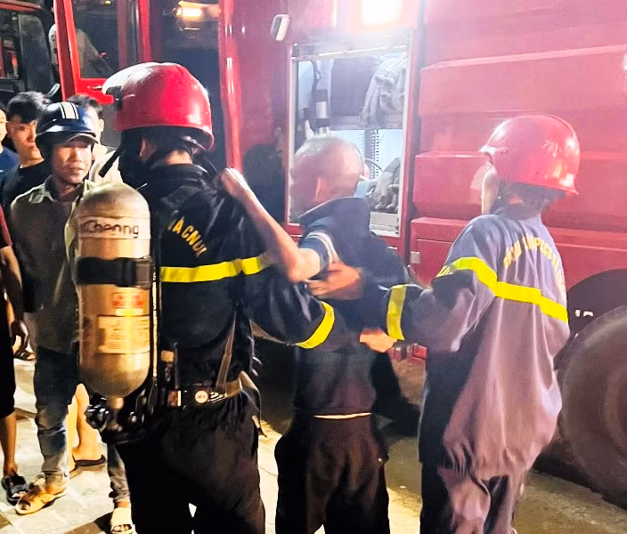 Lực lượng cứu hộ đưa người đàn ông khỏi khu vực hỏa hoạn.