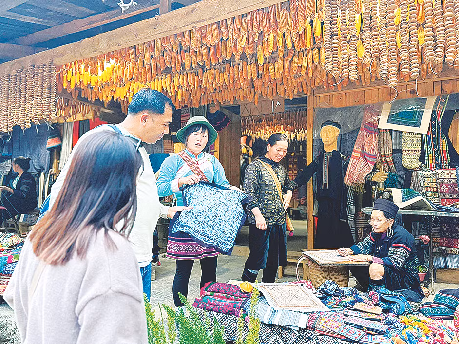 Du khách nước ngoài thích thú với các sản phẩm thổ cẩm tại bản Cát Cát.