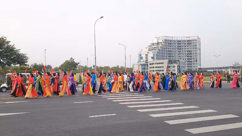 Từng đoàn phụ nữ mặc áo dài diễu hành trên đường Võ Văn Kiệt, phường 9, thành phố Vĩnh Long.