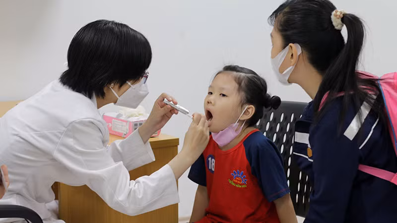 Các trẻ em được bác sĩ khám, tầm soát sức khỏe.