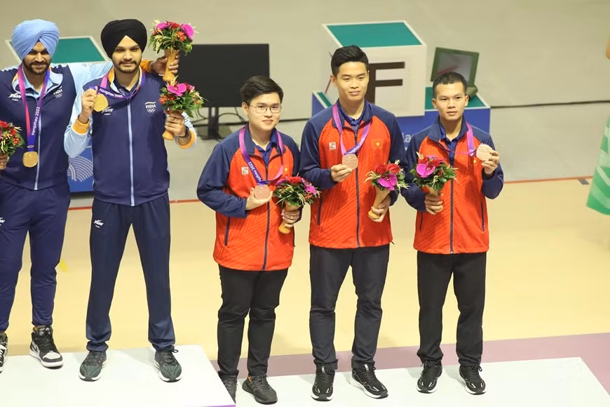 Phạm Quang Huy (giữa) còn giành Huy chương Đồng nội dung súng ngắn hơi 10m đồng đội cùng với Phan Công Minh và Lại Công Minh. (Ảnh: TTXVN phát)