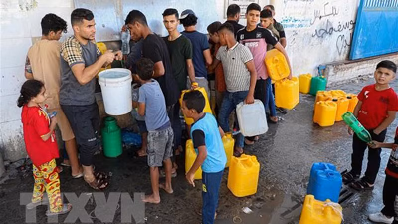 Người dân Palestine xếp hàng chờ lấy nước tại thành phố Khan Younis, miền nam Dải Gaza. (Ảnh: THX/TTXVN)