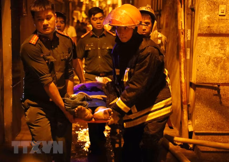 Lực lượng chức năng đưa nạn nhân ra khỏi hiện trường. (Ảnh: Phạm Kiên/TTXVN)