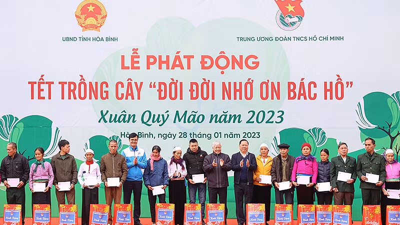 Các đồng chí Đỗ Văn Chiến, Nguyễn Phi Long, Bùi Quang Huy (lần lượt thứ 9, 8 và 13 từ phải sang) trao quà tặng đại diện các gia đình chính sách, hộ dân có hoàn cảnh khó khăn tại buổi lễ.