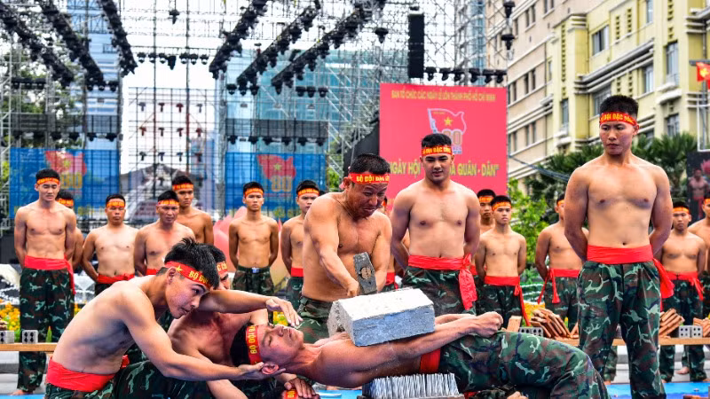 Bộ đội đặc công trình diễn tiết mục đập vỡ đá trên ngực. (Ảnh: Hữu Tân)