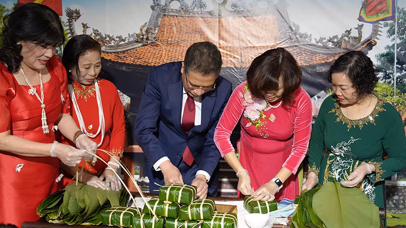 Đại sứ Đặng Minh Khôi cùng phu nhân gói bánh chưng theo phong tục truyền thống của dân tộc. (Ảnh: XUÂN HƯNG)