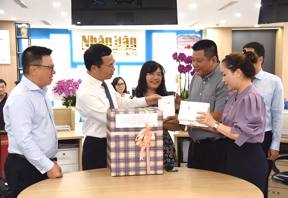 Bộ trưởng Nguyễn Mạnh Hùng tặng quà lãnh đạo Ban Nhân Dân điện tử. (Ảnh: Trần Hải)