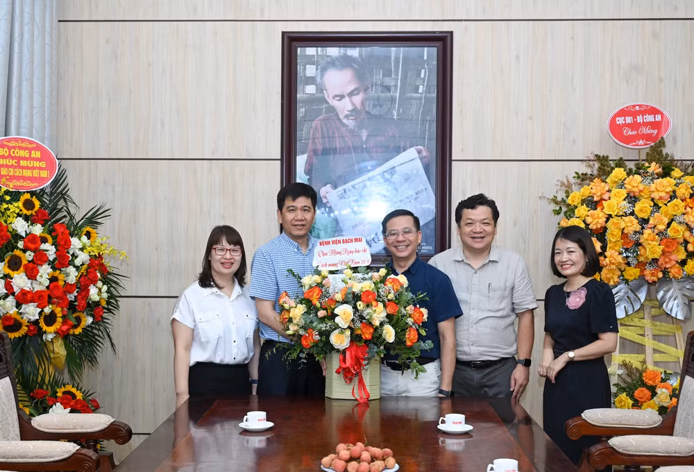 Đại diện lãnh đạo Báo Nhân Dân nhận lẵng hoa chúc mừng của Bệnh viện Bạch Mai. (Ảnh: DUY LINH)