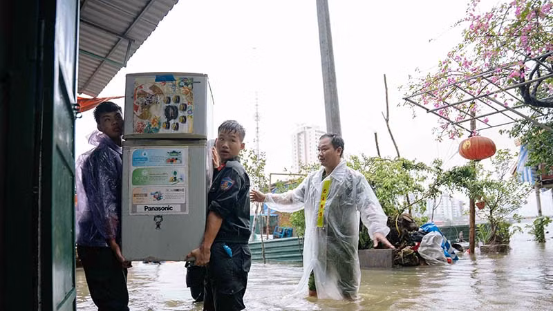 Các chiến sĩ công an tỉnh Hà Nam giúp nhân dân vận chuyển đồ đạc để tránh nước ngập.