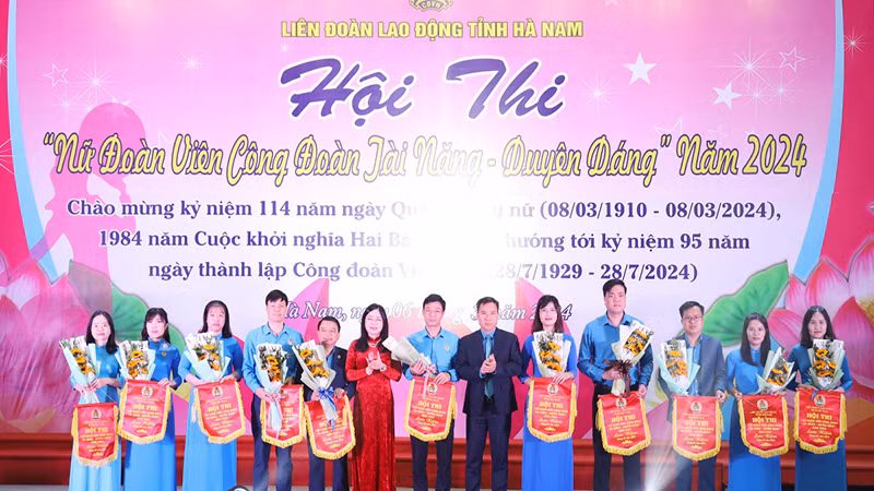 Lãnh đạo Liên đoàn Lao động tỉnh Hà Nam tặng hoa và cờ lưu niệm cho các đơn vị tham dự hội thi.