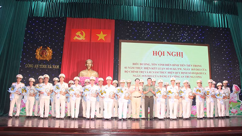 Đại diện lãnh đạo Bộ Công an và Công an tỉnh Hà Nam tặng biểu trưng và hoa cho các tập thể điển hình tiên tiến. 