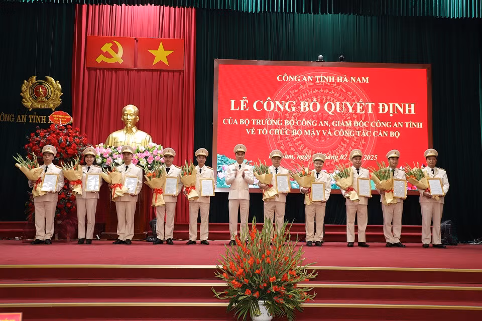 Đồng chí Giám đốc Công an tỉnh Hà Nam trao quyết định, tặng hoa chúc mừng các đồng chí lãnh đạo cấp phòng nhận công tác mới.