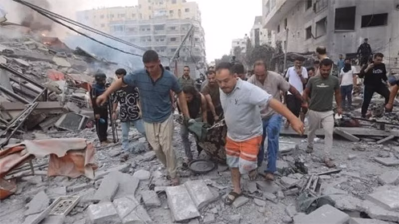 Chuyển thi thể nạn nhân sau các cuộc không kích của Israel xuống Dải Gaza. Ảnh: IRNA/TTXVN