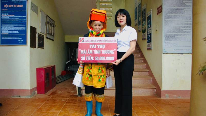 Đại diện lãnh đạo Ngân hàng nông nghiệp và Phát triển nông thôn chi nhánh (Agribank) Lạng Sơn, trao tặng, tài trợ tiền xây nhà cho gia đình Chị Hoàng Múi Phin. 