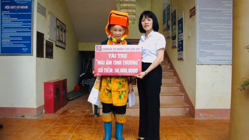 Đại diện lãnh đạo Ngân hàng nông nghiệp và Phát triển nông thôn chi nhánh (Agribank) Lạng Sơn, trao tặng, tài trợ tiền xây nhà cho gia đình Chị Hoàng Múi Phin. 