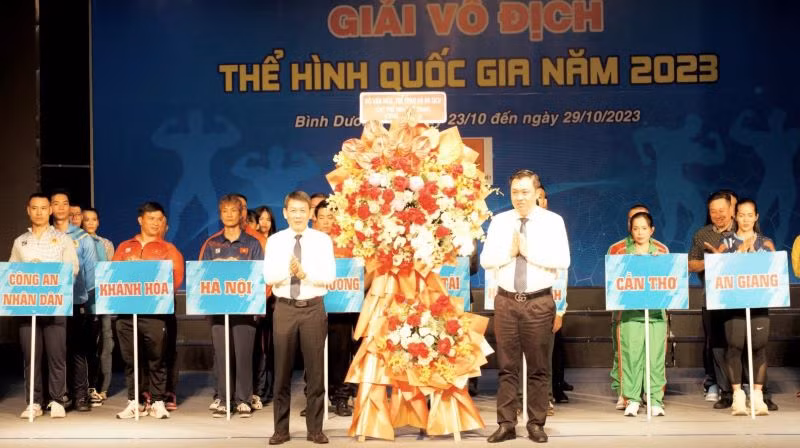 Đại diện Bộ Văn hóa, Thể thao và Du lịch (bên trái) trao hoa cảm ơn địa phương đăng cai giải.