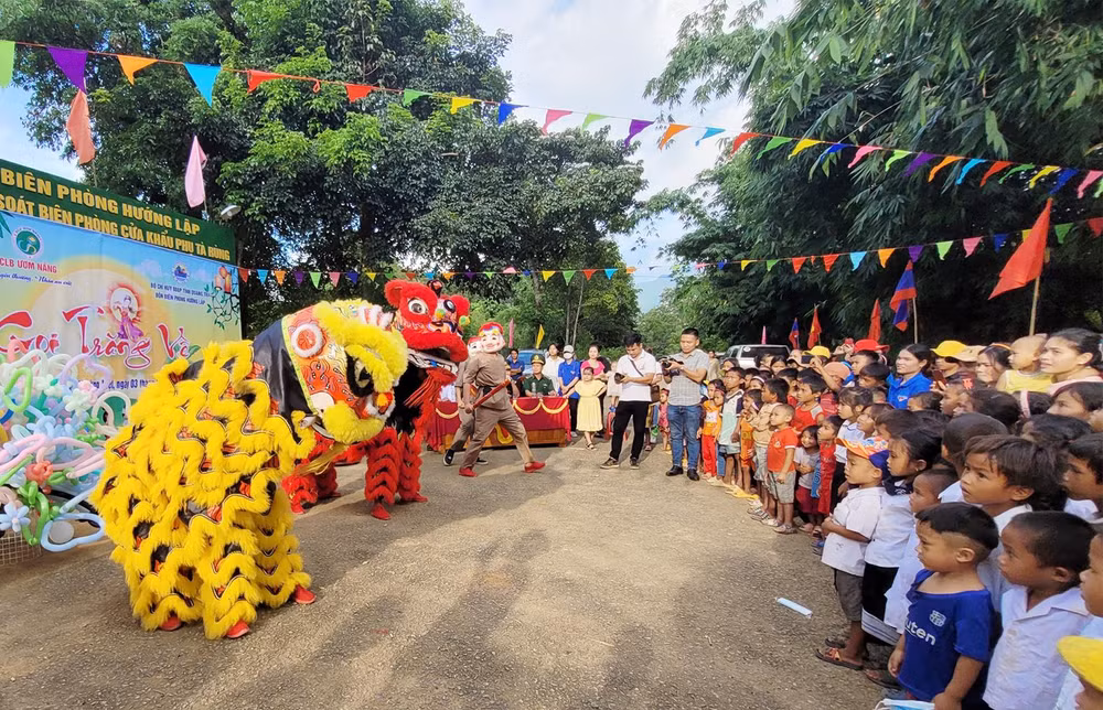 Trẻ em vùng biên giới hai nước xem múa lân sư rồng.