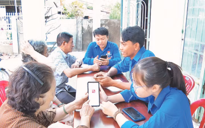Đoàn viên thanh niên tỉnh Bình Phước hướng dẫn người dân sử dụng ứng dụng định danh điện tử.