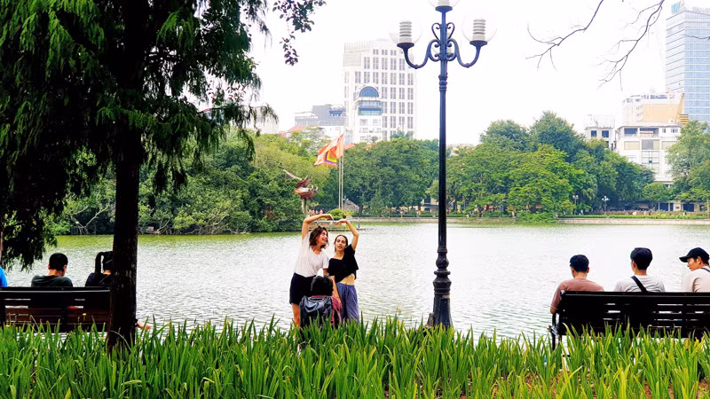 Du khách nước ngoài chụp ảnh tại Hồ Gươm, Hà Nội (Ảnh: T.LINH)