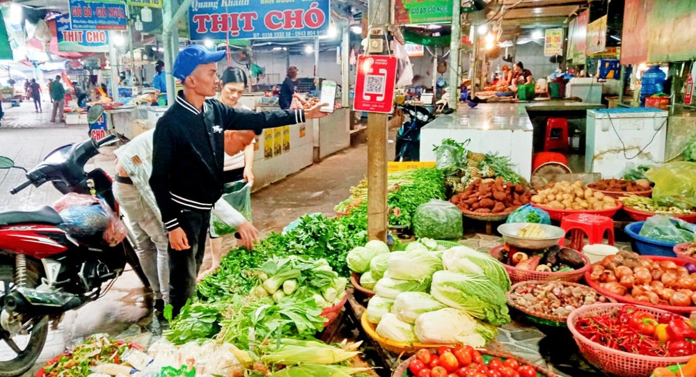 Người mua hàng tại chợ Đại Từ quét mã QR để thanh toán tiền.