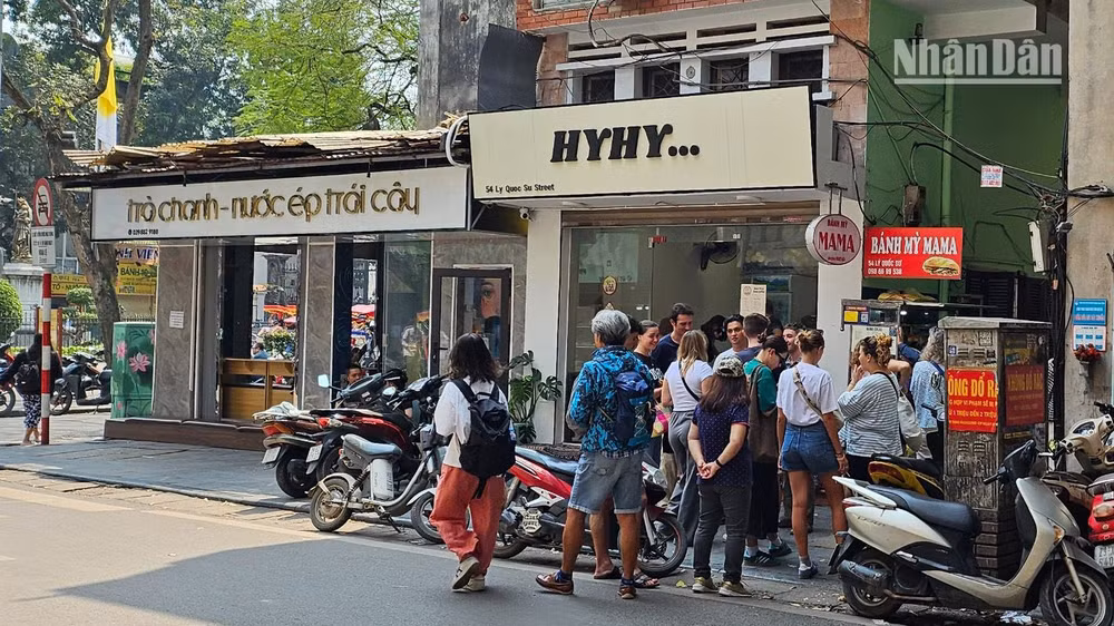 Khách du lịch nước ngoài đứng xếp hàng chờ mua bánh mì tại một cửa hàng nhỏ trên phố Lý Quốc Sư, Hà Nội. (Ảnh: T.LINH)