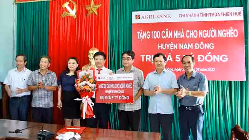 Ông Nguyễn Hải Quân, Giám đốc Agribank Thừa Thiên Huế (bên trái) trao biểu trưng tặng 100 căn nhà cho lãnh đạo huyện Nam Đông để hỗ trợ xây nhà cho hộ nghèo.