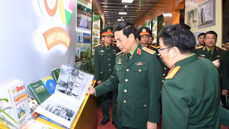 Đại tướng Phan Văn Giang và các đại biểu tham quan gian trưng bày về nhiếp ảnh quân đội. (Ảnh: QĐND)