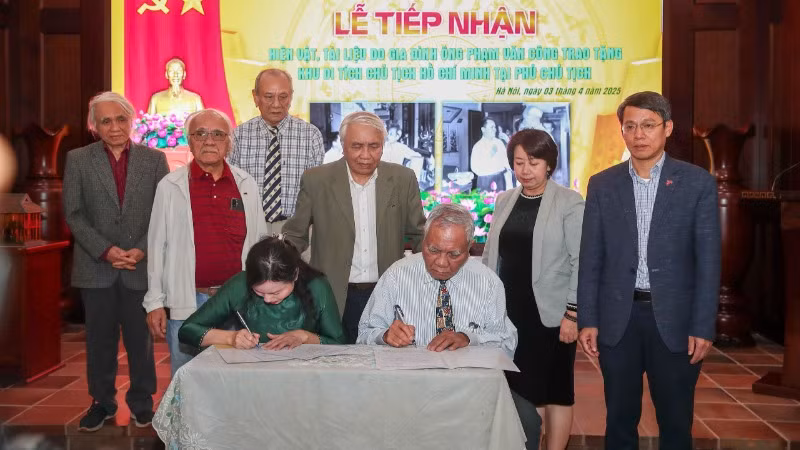 Đại diện Khu Di tích Chủ tịch Hồ Chí Minh tại Phủ Chủ tịch và đại diện gia đình cụ ông Phạm Văn Công ký biên bản giao nhận hiện vật. (Ảnh: NAM NGUYỄN)