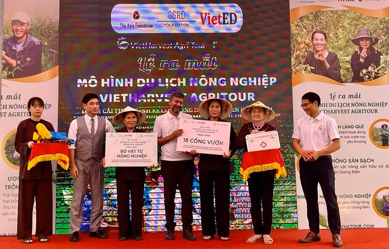 Đại diện dự án trao tặng vật tư nông nghiệp cho đại diện các hộ nông dân.
