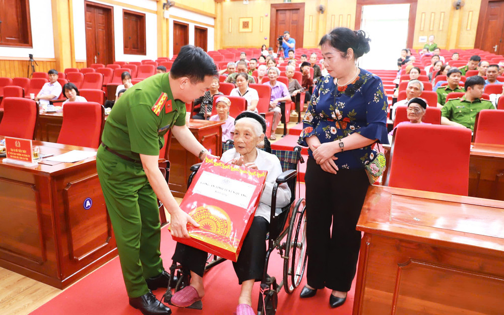 Đại tá Đỗ Tiến Thùy, Phó Giám đốc Công an tỉnh Tuyên Quang tặng quà Mẹ Việt Nam Anh hùng, mẹ liệt sĩ tham gia lấy mẫu.