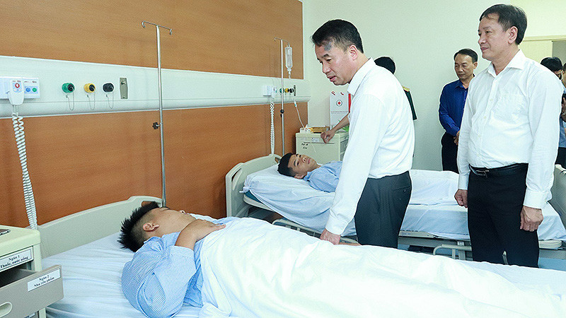 Tổng Giám đốc Bảo hiểm xã hội Việt Nam Nguyễn Thế Mạnh, Giám đốc Bảo hiểm xã hội Hà Nội thăm hỏi nạn nhân vụ cháy. (Ảnh: Khánh Duy)