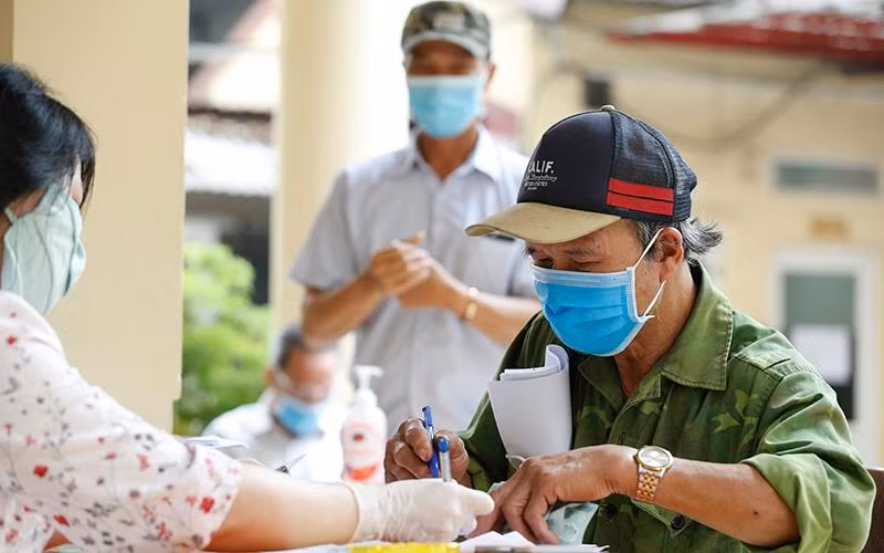 Chi trả tiền hỗ trợ dịch Covid-19 cho các đối tượng người có công và bảo trợ xã hội ở quận Đống Đa, Hà Nội vào tháng 5/2020. (Ảnh: Duy Linh)