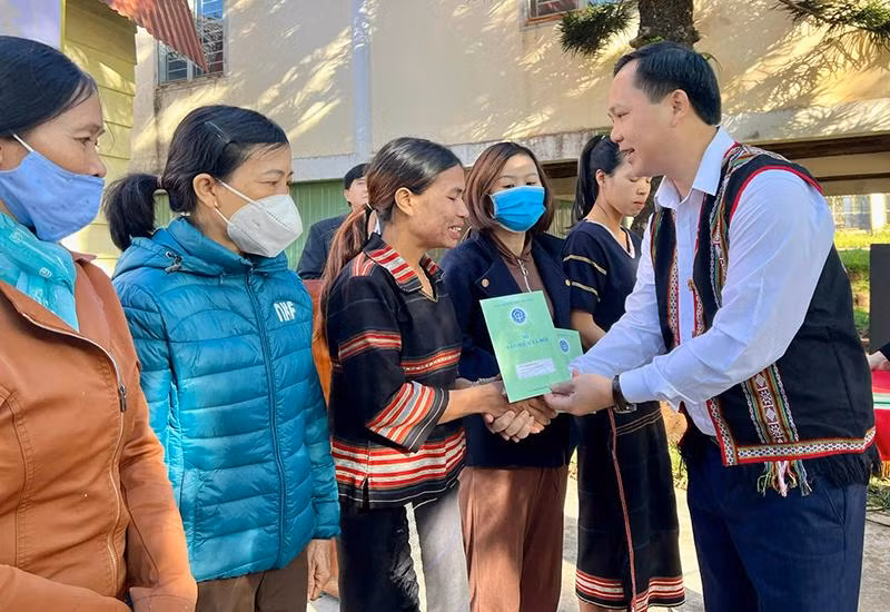 Đại diện Bảo hiểm xã hội Việt Nam trao tặng sổ bảo hiểm xã hội, thẻ bảo hiểm y tế cho người dân có hoàn cảnh khó khăn của làng Ia Nueng, xã Biển Hồ, thành phố Pleiku. (Ảnh: Bảo hiểm xã hội Gia Lai)