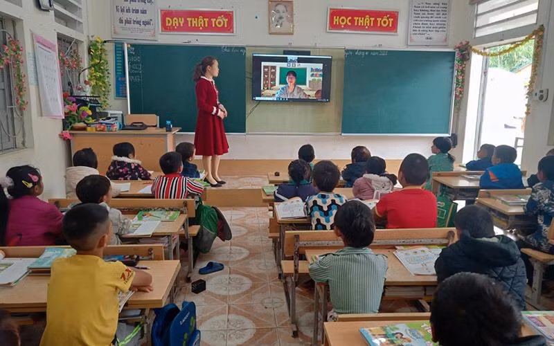 Học sinh Trường phổ thông Dân tộc bán trú tiểu học xã Thượng Phùng, huyện Mèo Vạc (Hà Giang) đang học Tiếng Anh trực tuyến với cô giáo Trường phổ thông liên cấp Marie Curie (Hà Nội) dưới sự hỗ trợ của giáo viên chủ nhiệm. (Ảnh KHÁNH TOÀN)