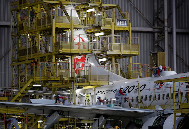 Các công nhân bảo trì một chiếc máy bay của Japan Airlines. (Ảnh: Reuters)