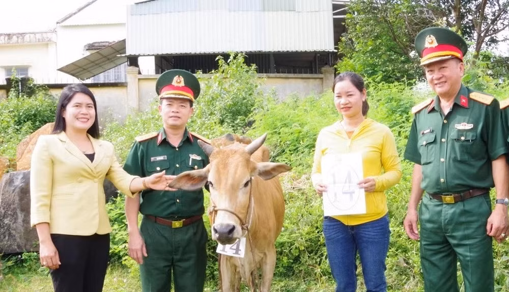Đại diện Binh đoàn 16 và Ủy ban nhân dân huyện Bù Đăng tặng bò giống cho người nghèo.