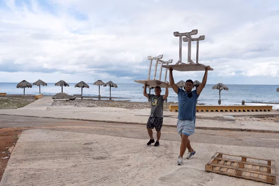 Người dân dọn dẹp đồ đạc trước khi bão Rafael đổ bộ vào Cuba. Ảnh: Reuters