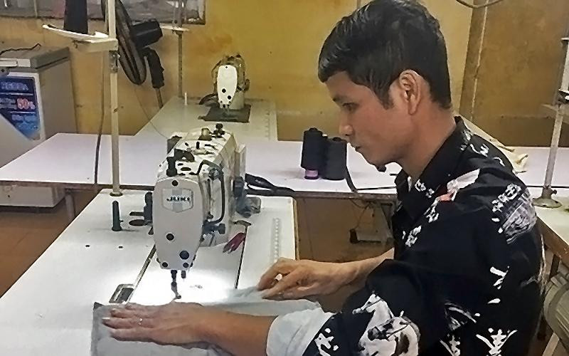 Anh Lường Văn Hiếu, một trong những tấm gương “Tỏa sáng nghị lực Việt”, cần mẫn lao động trên bàn may mỗi ngày.