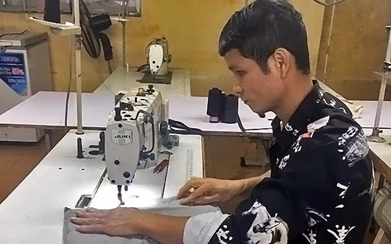 Anh Lường Văn Hiếu, một trong những tấm gương “Tỏa sáng nghị lực Việt”, cần mẫn lao động trên bàn may mỗi ngày.