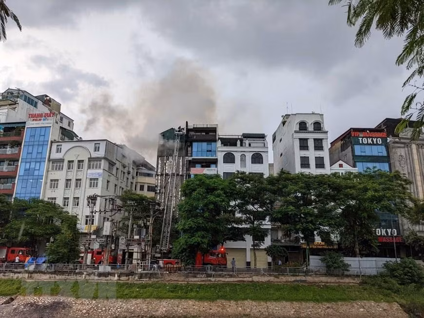 Cảnh sát phòng cháy chữa cháy và cứu nạn, cứu hộ, Công an thành phố Hà Nội đã dùng xe thang đưa lực lượng chữa cháy lên khu vực tầng thượng của ngôi nhà. (Ảnh: TTXVN)